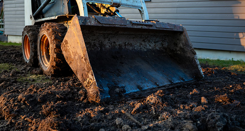 If your yard has serious puddling, water running toward the house, or long-standing soggy zones, that is not a rake-and-shovel problem to handle by yourself.