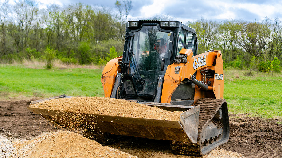LawnCare by Walter employee operating a CASE compact track loader for site grading and landscape excavation.